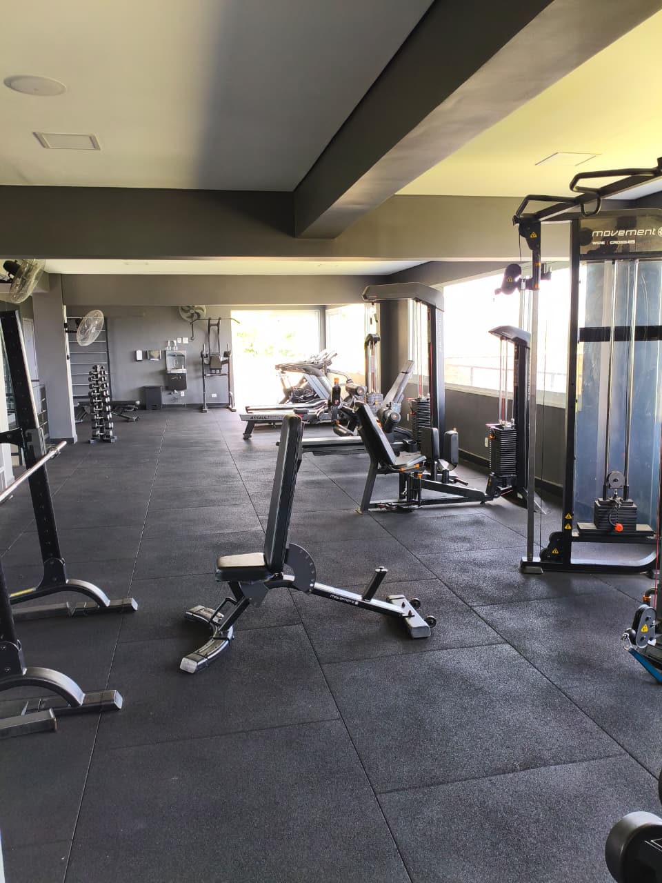 Sala de musculação com aparelhos modernos e iluminação natural