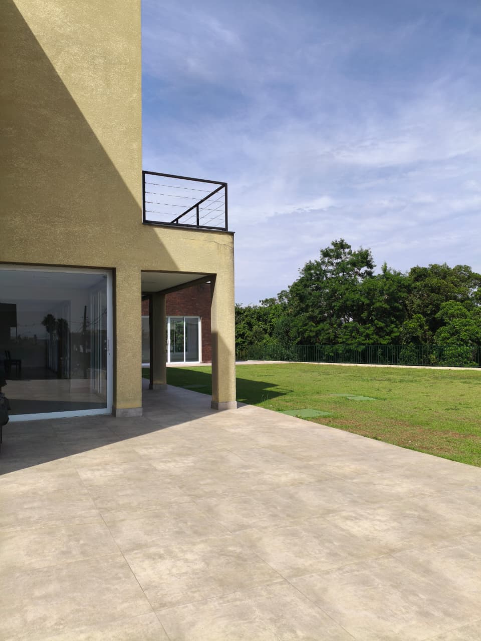Fachada do anexo do Salão de Festas com o canteiro ajardinado e o piso externo