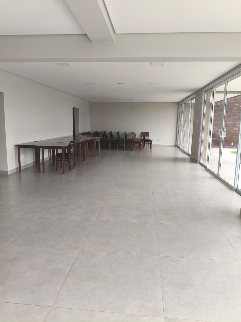 Interior do Salão de Festas amplo com pé-direito alto e integração com a área externa